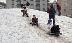 Erzurum'da kar yağışını fırsat bilen çocuklar mahalle aralarında poşet ve kızakla kaydı