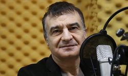 Doktor önlüğüyle hastanede, mikrofon başında radyoda