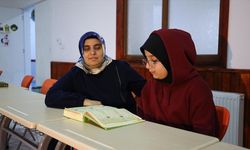 Çevresini silüet olarak gören kadın, yediden yetmişe Kur'an-ı Kerim öğretiyor