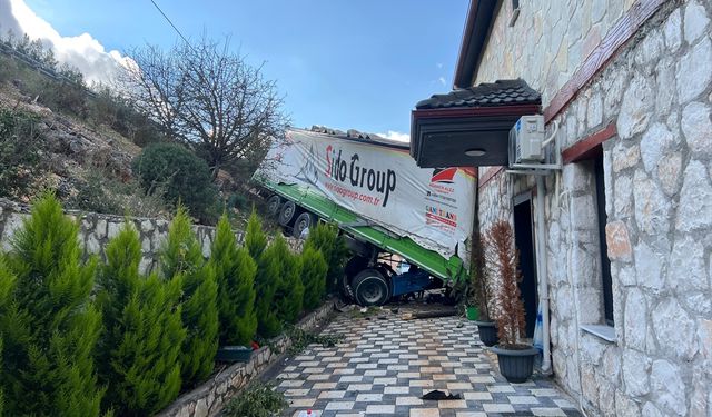 Antalya'da şarampole devrilen tırın bir eve çarparak durabildiği kazada sürücü yaralandı